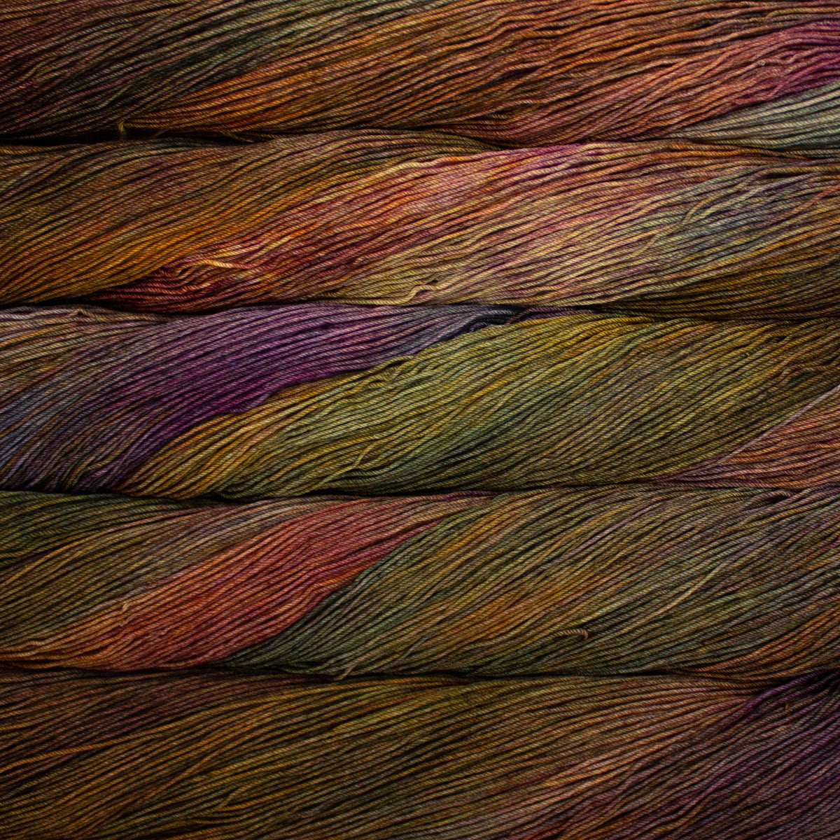 Close-up of multicolored yarn with shades of orange, green, purple, and brown.