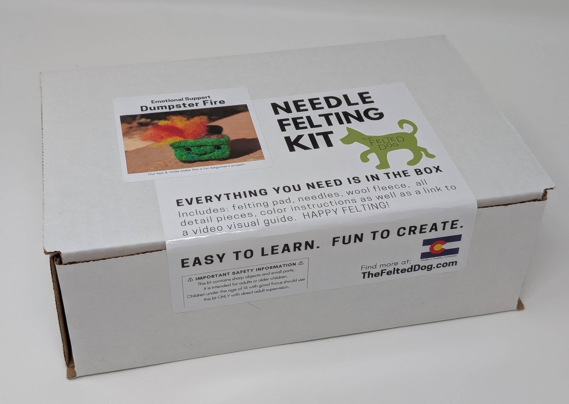 Box containing a needle felting kit with branding and product details on a white background
