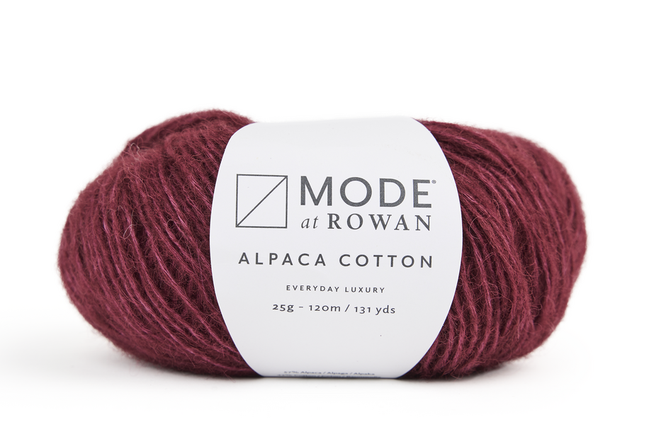 Ball of red yarn with a Rowan label on a white background