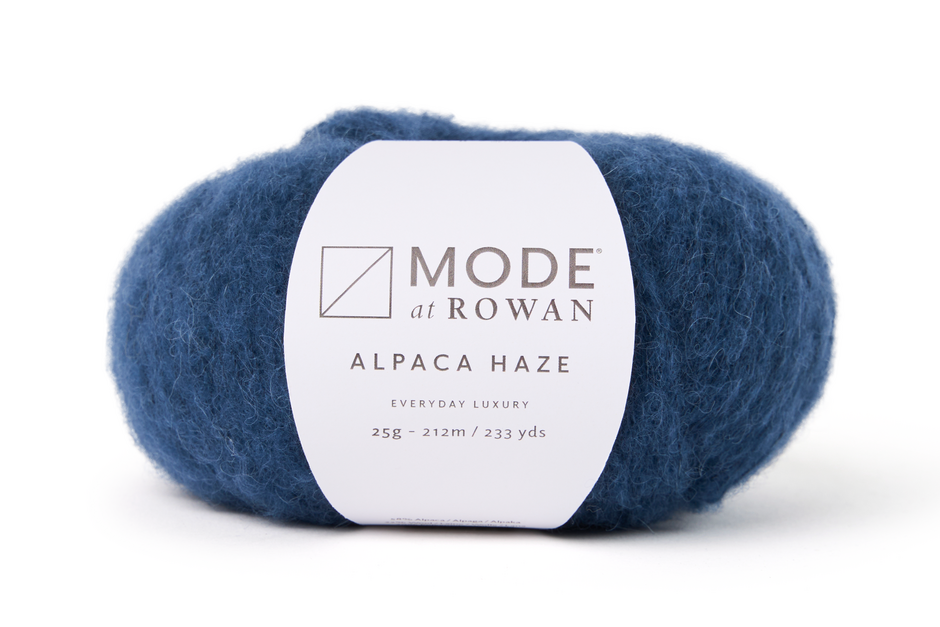 Blue skein of yarn with a white label on a white background
