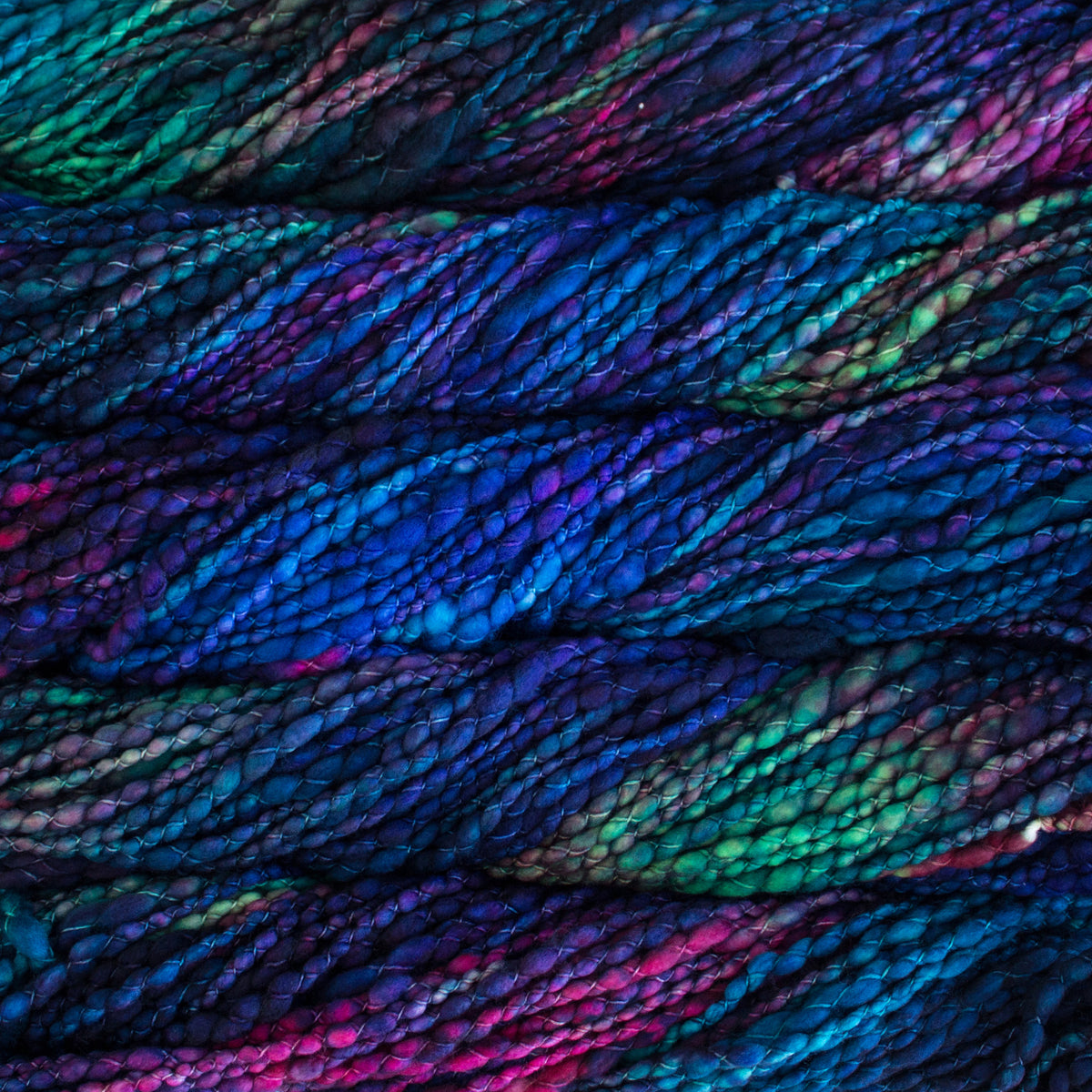 Close-up of variegated yarn of deep blue, purple, teal, and magenta.
