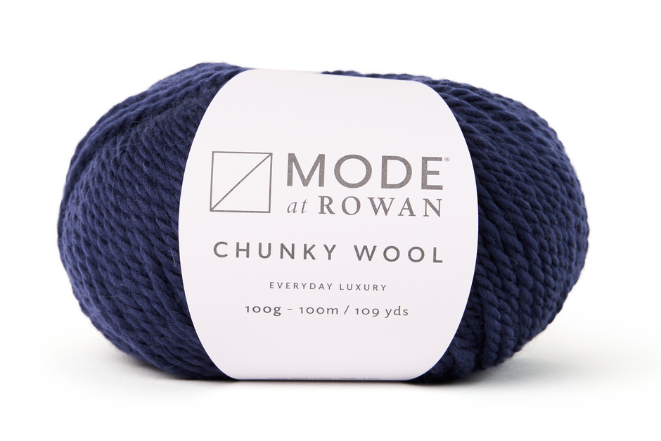 Navy blue skein of yarn with a white label on a white background