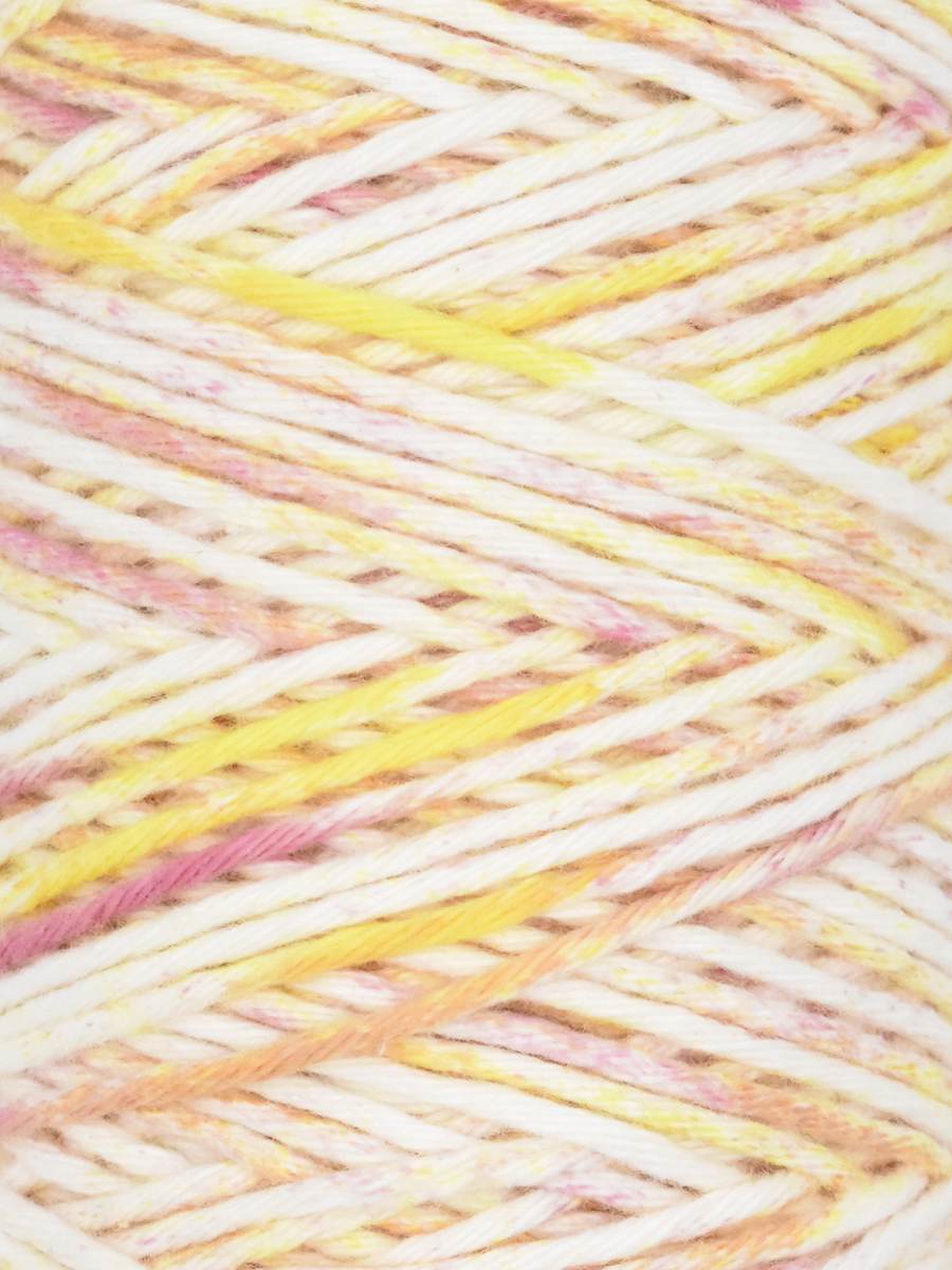Close-up of speckled yarn with hues of cream, pale yellow, and soft pink.