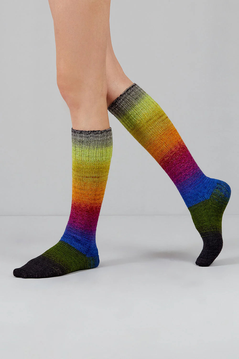 A pair of rainbow gradient socks shown on feet against a white background