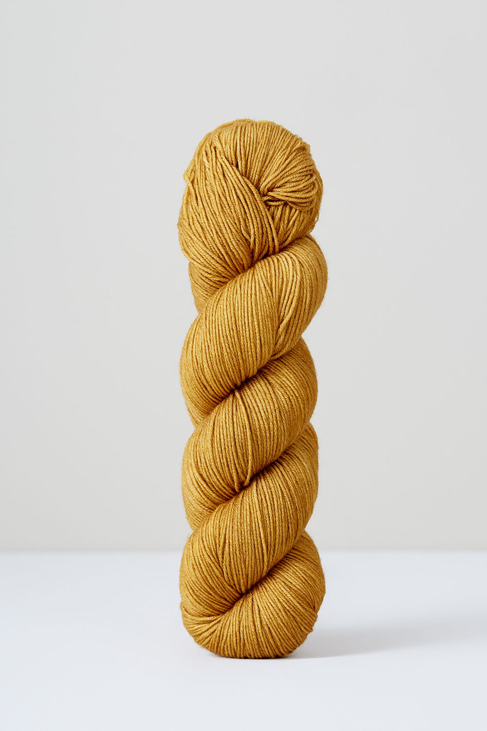 Mustard yellow skein of yarn on a white background