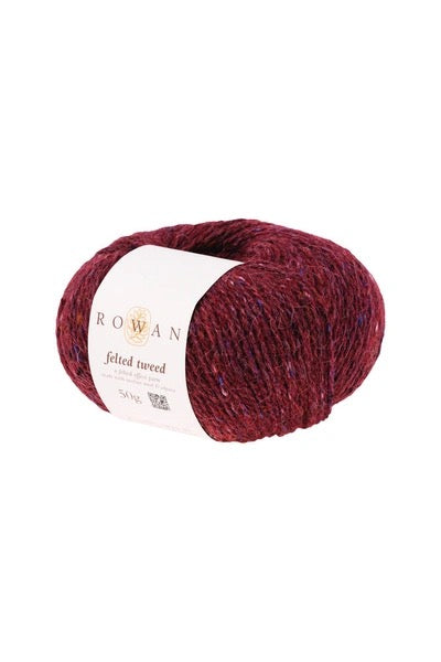 A skein of Rowan Felted Tweed yarn in a deep brick red color, wrapped with a white paper label, on a plain white background.