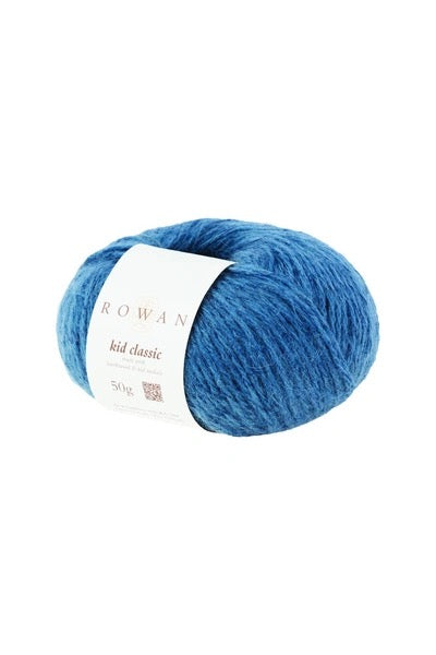 A skein of blue yarn with a white paper label reading 'ROWAN kid classic' on a plain white background.