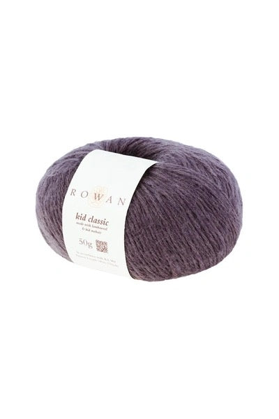 A skein of Rowan Kid Classic yarn in a dusty purple shade, wrapped with a white paper label, on a solid white background.