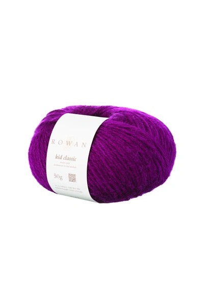 A single skein of Rowan Kid Classic yarn in a vibrant purple color, wrapped with a white paper label, set against a plain white background.