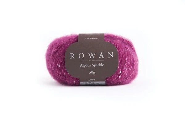 Magenta color Ball of yarn with white sequins with Rowan label on a white background
