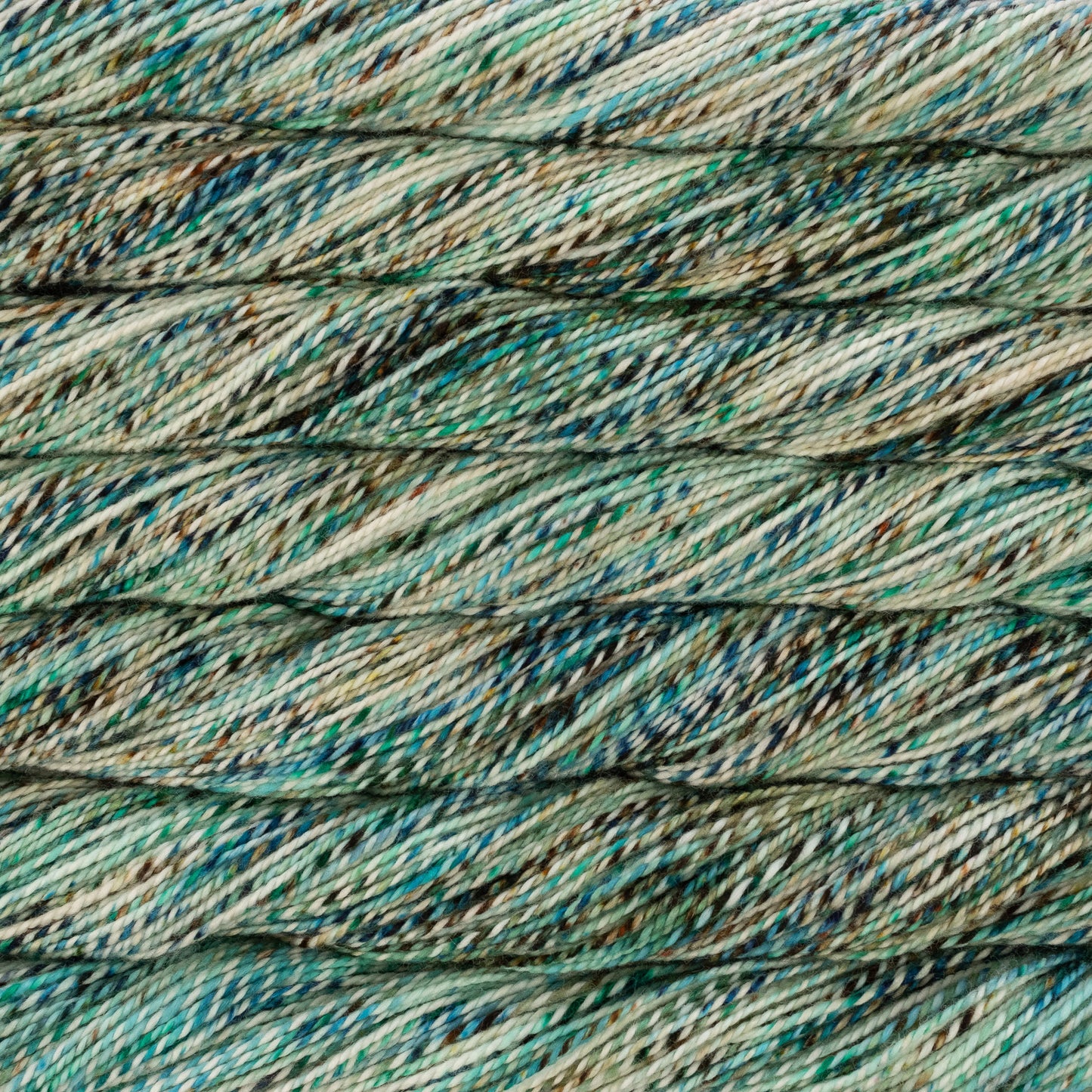 Close-up of multicolored yarn with shades of green, blue, and brown.