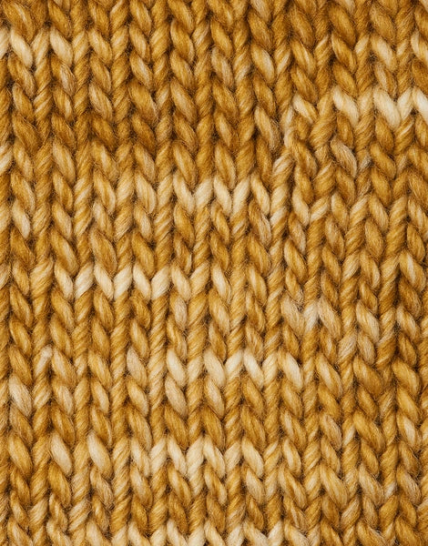 A close-up of a knitted fabric texture in a mustard yellow